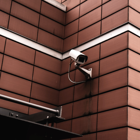 SGF Elektrotechnik - Weiße Überwachungskamera an roter Wand